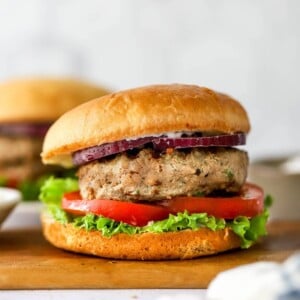 Turkey burger assembled on a bun with tomato, lettuce and red onion.