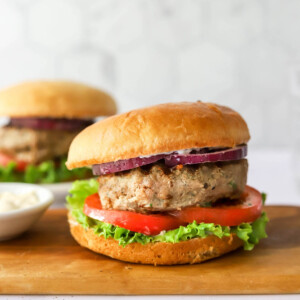 Turkey burger assembled on a bun with tomato, lettuce and red onion.