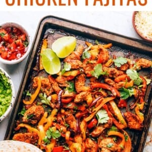 Chicken fajita filling on a sheet pan with a wooden spoon. Tortillas are resting on the bottom of the sheet pan.