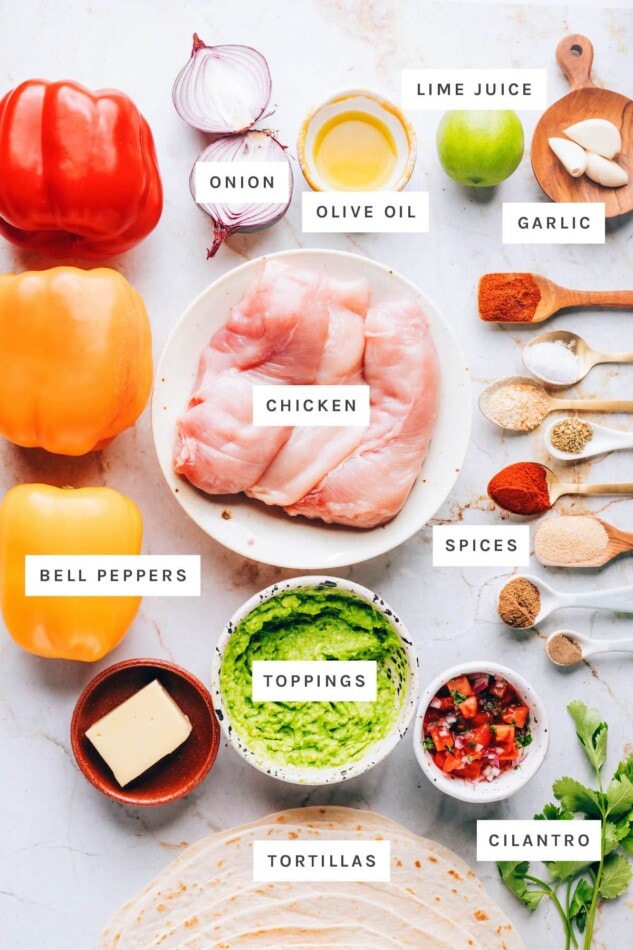 Ingredients measured out to make sheet pan chicken fajitas: onion, olive oil lime, garlic, chicken, bell peppers, spices, toppings, cilantro and tortillas.