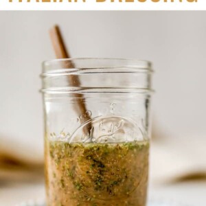 Homemade Italian dressing in a mason jar with a spoon.