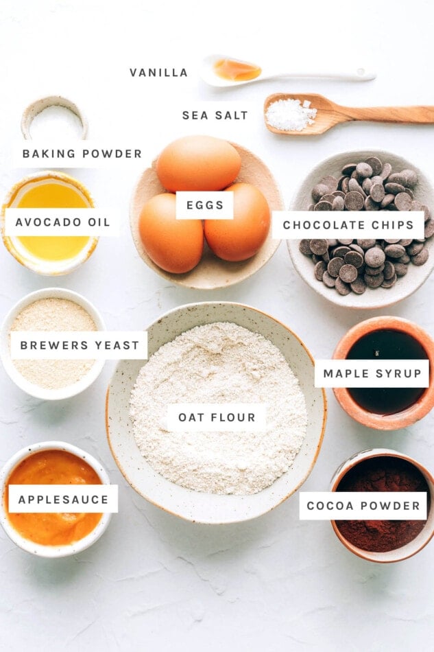 Ingredients measured out to make lactation brownies: vanilla sea salt, baking powder, eggs, chocolate chips, avocado oil, brewers yeast, oat flour, ample syrup, applesauce and cocoa powder.