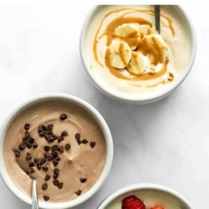 Three small dishes containing protein pudding: peanut butter, chocolate and vanilla.