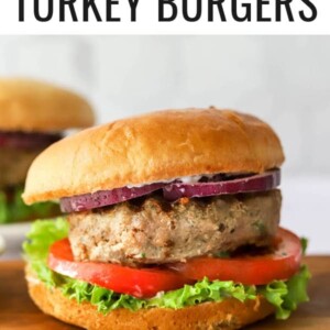 Turkey burger assembled on a bun with tomato, lettuce and red onion.