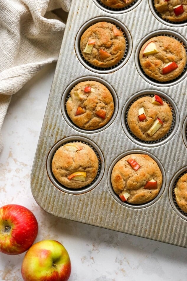 Baked apple yogurt muffins in a muffin tin.