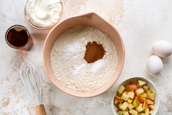 Mixing together flour, baking powder, baking soda, salt and cinnamon.