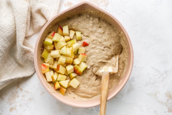 Folding in apples into the yogurt muffin batter.