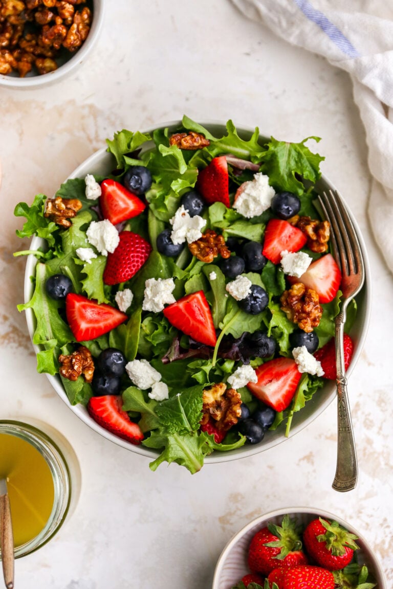 A bowl with summer berry salad. A fork rests on bowl.