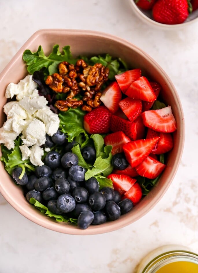 Ingredients for summer berry salad in a mixing bowl.