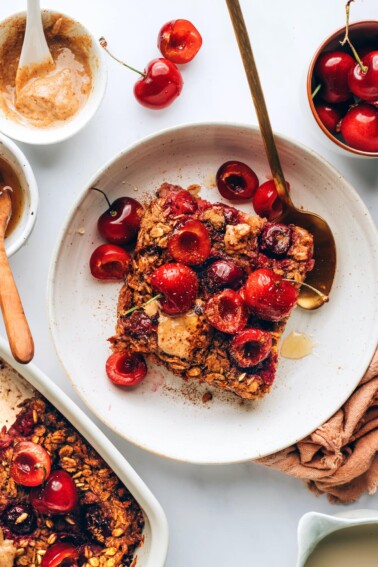 A serving of cherry baked oatmeal on a plate with a spoon.