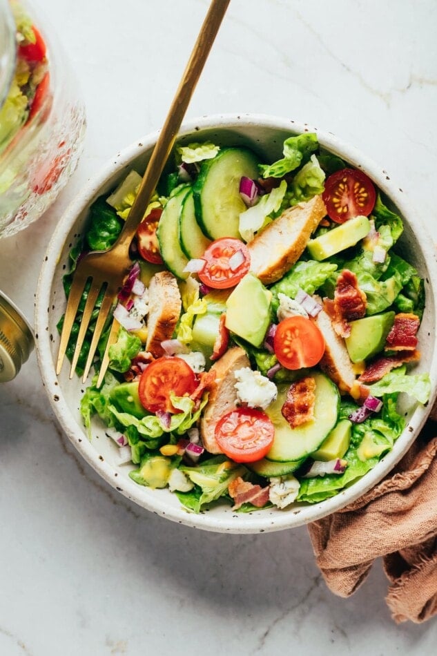 Chicken avocado club salad served in a bowl.