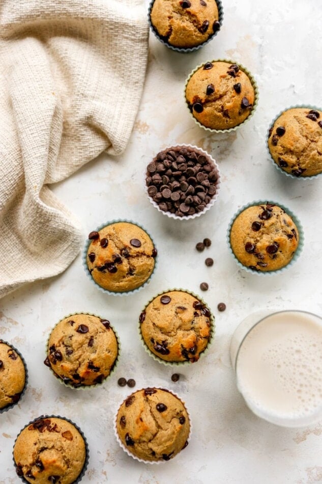 Overhead view of 10 chocolate chip yogurt muffins with a silicone liner containing extra chocolate chips.