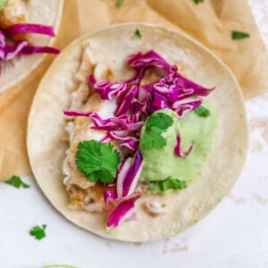 Overhead view of a fish taco on a piece of parchment paper.