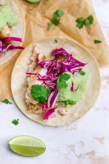 Overhead view of a fish taco on a piece of parchment paper.