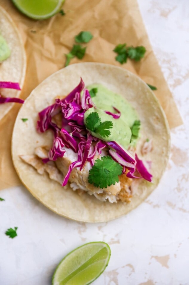 Overhead view of a fish taco on parchment paper.