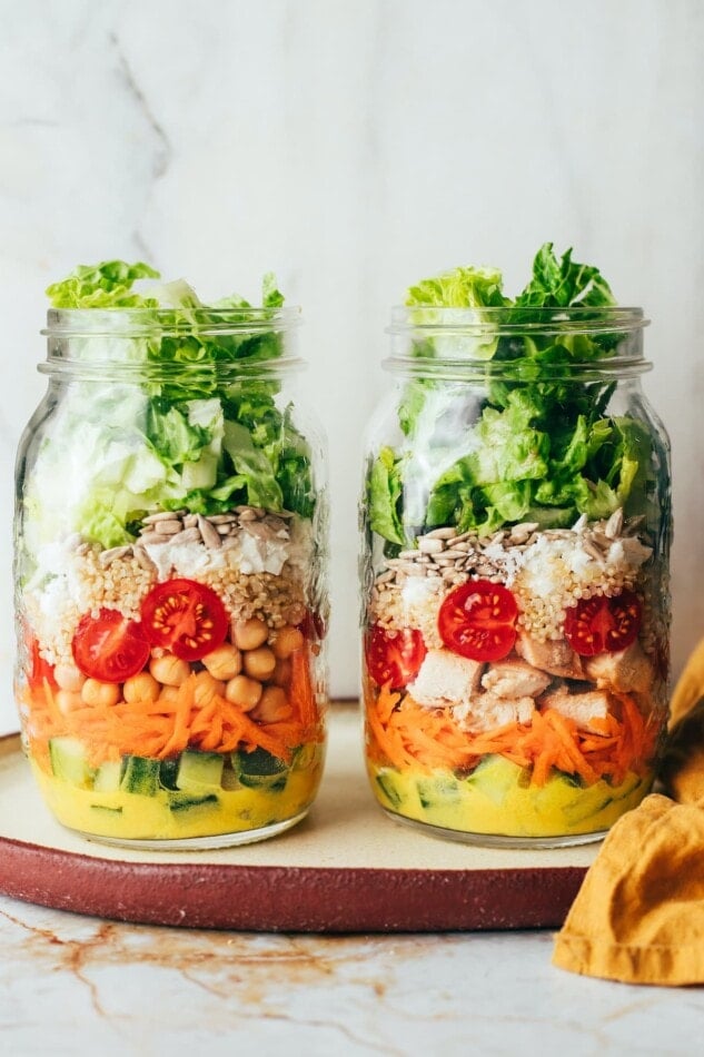 Topping mason jars with salad greens.