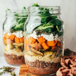 Two jars containing sweet potato and lentil salad.