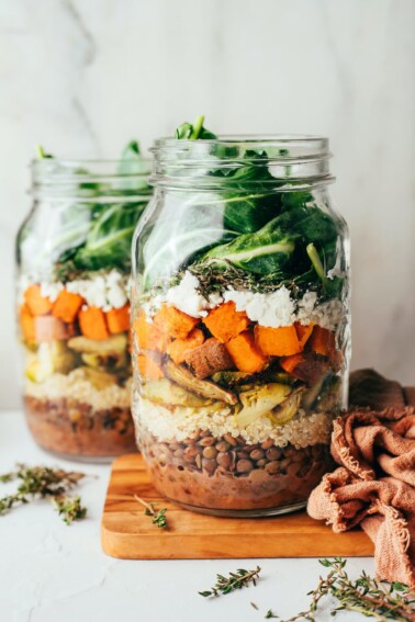 Two jars containing sweet potato and lentil salad.