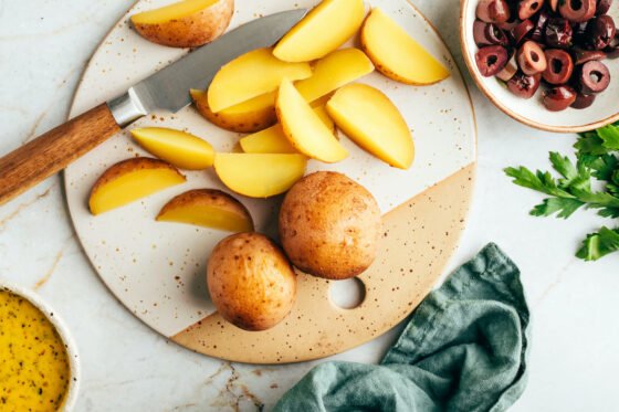 Chopping potatoes on a cutting board.