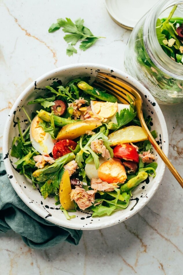 Nicoise salad in a serving bowl with a fork.