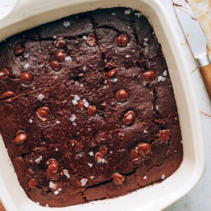 An 8x8 baking dish with oat flour brownies cut into 9 bars.