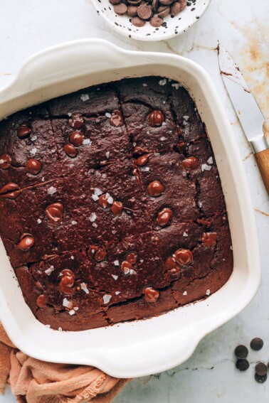 An 8x8 baking dish with oat flour brownies cut into 9 bars.