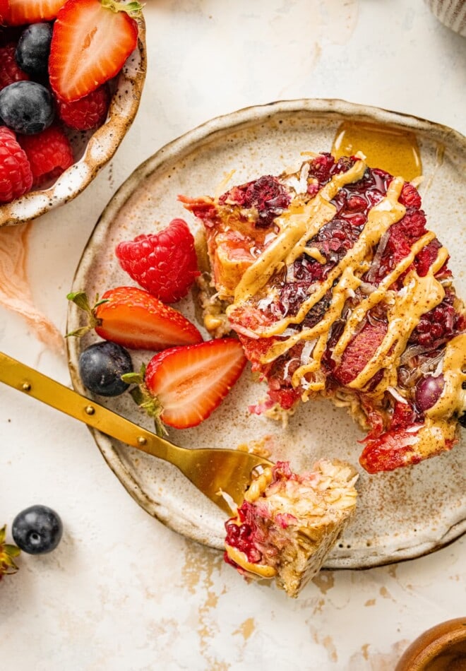 Overhead view of a serving of baked oatmeal on a plate with a bite resting on a fork.