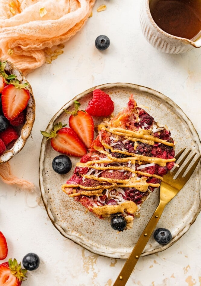 A serving of baked oatmeal on a plate, a fork rests on the plate too.