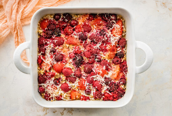 One pan baked oatmeal with berries and coconut flakes in a square baking dish.