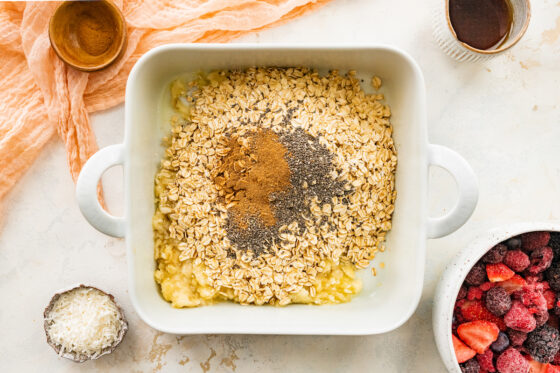 Chia seeds and cinnamon added to square baking dish.