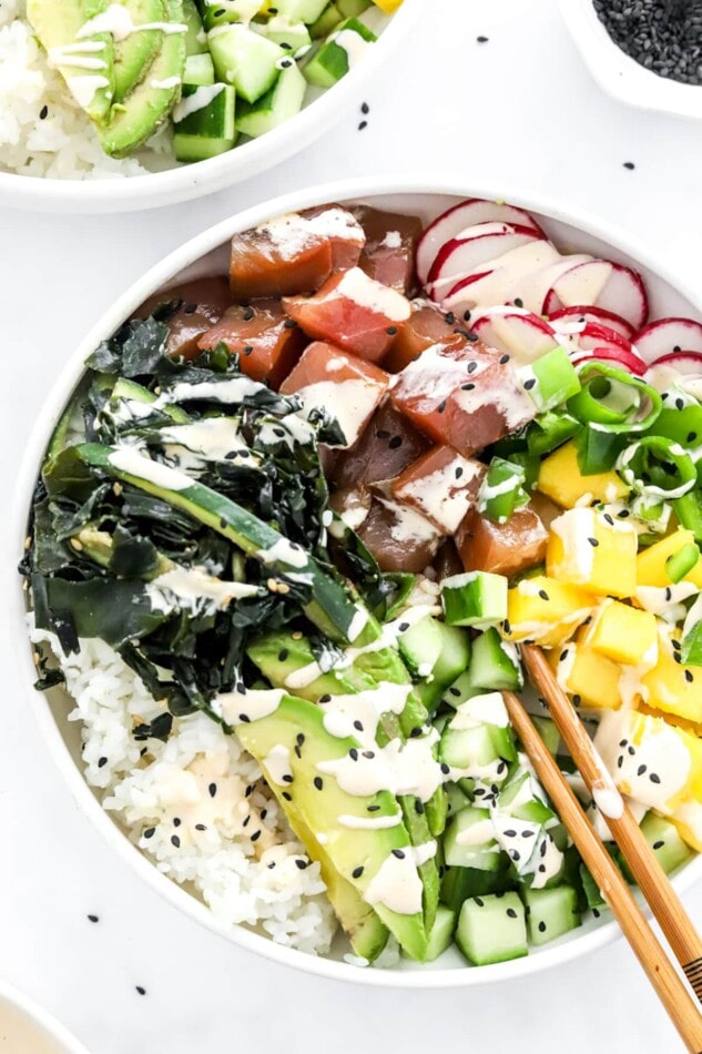 Close up of poke bowl. Chopsticks rest in the bowl.