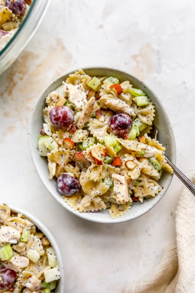 An overhead view of a bowl with poppyseed chicken pasta salad and a spoon.