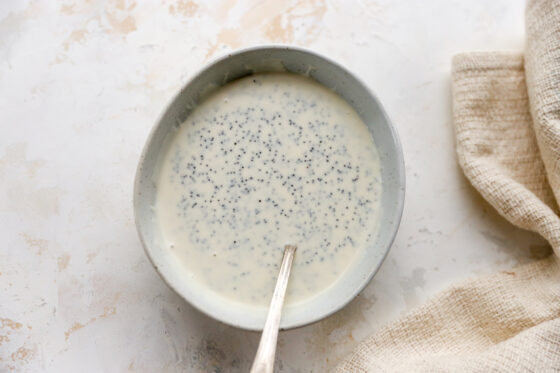 Poppyseed dressing in a mixing bow with a spoon.