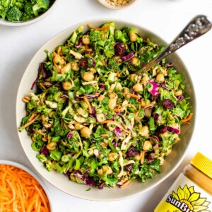 Overhead view of a bowl of sunflower crunch salad with a jar of SunButter sunflower seed butter.