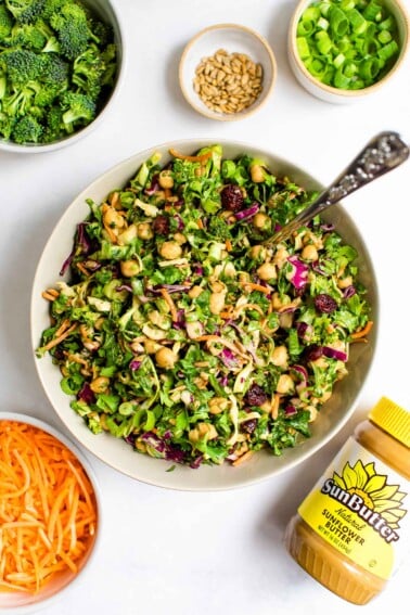 Overhead view of a bowl of sunflower crunch salad with a jar of SunButter sunflower seed butter.