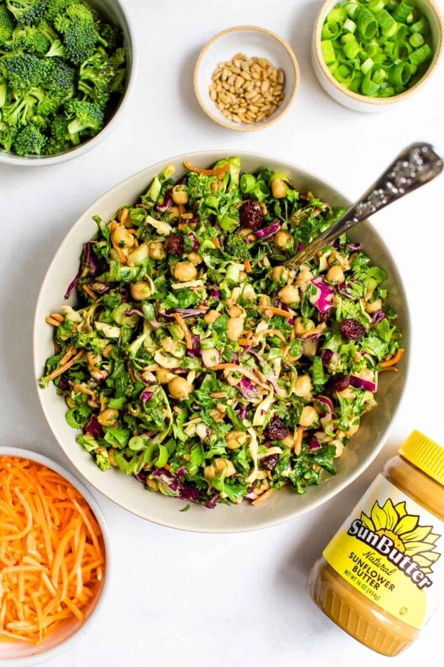 Overhead view of a bowl of sunflower crunch salad with a jar of SunButter sunflower seed butter.