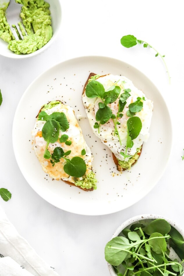 Avocado and egg sweet potato toast on a plate.