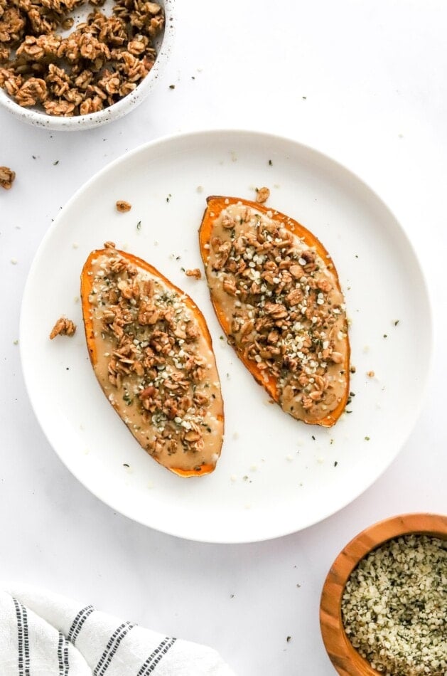 Nut butter and granola sweet potato toast slices on a plate.