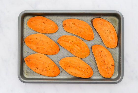 Sliced sweet potato on a baking sheet.