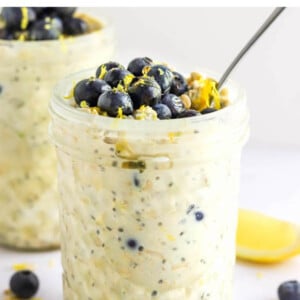 Jar of blueberry lemon overnight oats topped with blueberries and lemon zest.