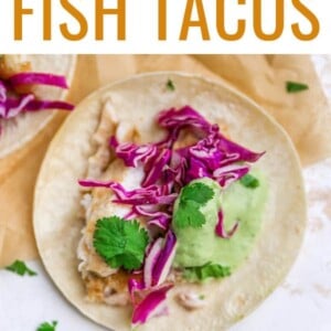 Fish taco topped with slaw and avocado crema.