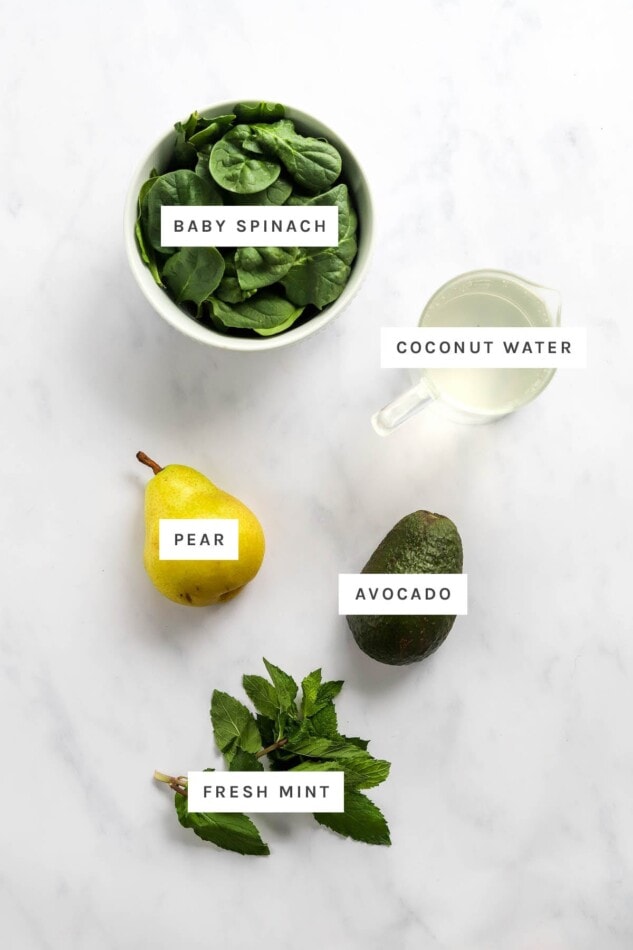 Ingredients measured out to make a Pear Smoothie: baby spinach, coconut water, pear, avocado and fresh mint.