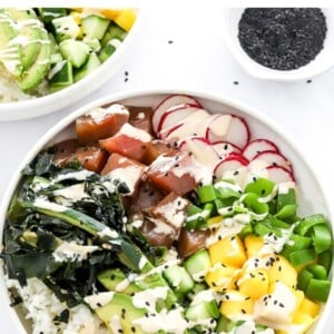 Homemade tuna poke bowl topped with black sesame seeds and sriracha mayo.