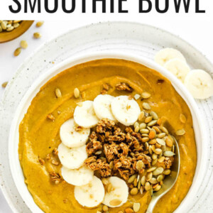 A pumpkin smoothie bowl topped with pumpkin seeds, granola and banana slices.