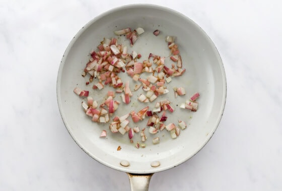 Sautéing onion and garlic in a pan.