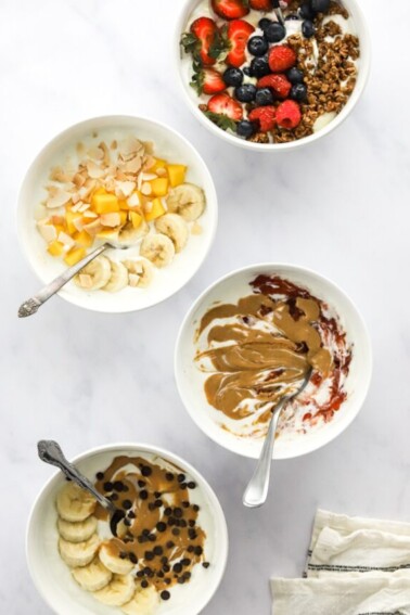 Overhead view of 4 different varieties of yogurt bowls.