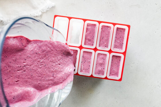 Pouring the mixture into popsicle molds.