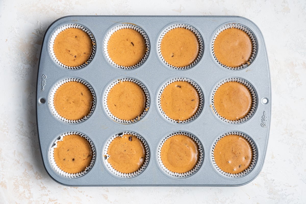 Protein muffin batter in a muffin tin with paper liners.