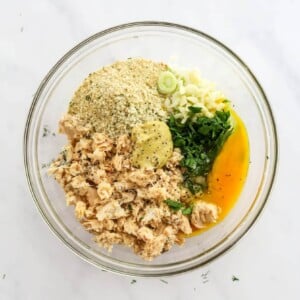 Salmon, bread crumbs, egg, garlic, scallions, dijon mustard, lemon juice, parsley, salt and pepper in a medium mixing bowl.