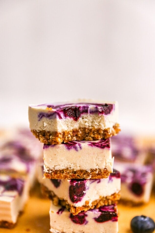Stacked cheesecake bars, the top bar has a bite taken out of it.